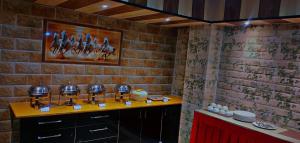 una stanza con un muro di mattoni e un tavolo con piatti di Peaceful & scenic Homestay in Shoghi-Shimla a Shimla