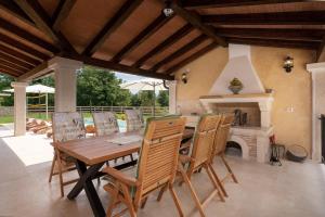 een eetkamer met een tafel en stoelen en een open haard bij Villa Lucija in Katun Gračanski