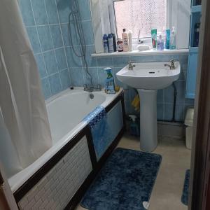 Alys apartment في لندن: حمام مع حوض وحوض استحمام ومغسلة
