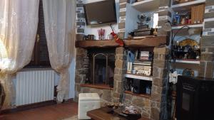 sala de estar con chimenea y TV en Casale Toscano in aperta campagna, en Figline Valdarno