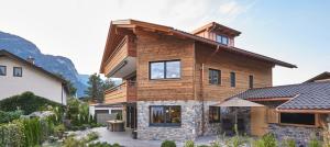une maison dans les montagnes avec une cour dans l'établissement Sunshine Apartment Wood'n Rustic, à Garmisch-Partenkirchen