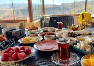 una mesa cubierta con platos de comida y bebida en crassula cave kapadokya hotel, en Nar
