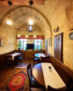 a restaurant with tables and chairs in a room at YOHANNES Stone Cappadocia in Ürgüp