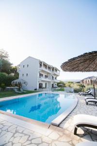 een villa met een zwembad en een gebouw bij Giorgos apartments in Dassia