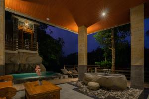 an outdoor patio with a tub and a pool at Ubud Paras Villa in Ubud