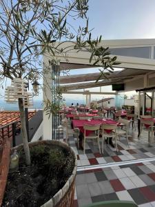 a restaurant with tables and chairs on a roof at Drommire In Plassa E Clesia in Baunei
