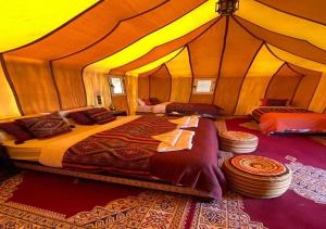 a bedroom with two beds in a tent at Desert Sparrow Luxury Camp in Merzouga