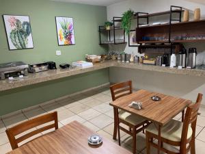 a dining room with two tables and a counter at Hotel Ouro Verde in Três Pontas