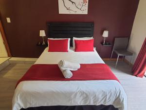a bedroom with a large bed with red pillows at The Crooked Forest in Pretoria