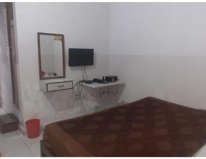 a bedroom with a bed and a mirror and a television at Hotel Vishal, Gaya in Gaya