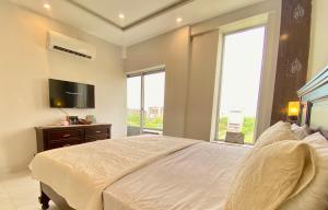 a bedroom with a large bed and a television at 1-Bed Elegant Condo at Eiffel TW in Rāmkot
