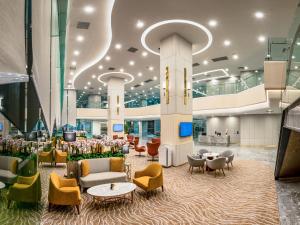 a lobby with chairs and tables in a building at Sunway Sanctuary - Seniors Hotel & Residences in Subang Jaya