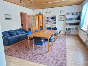 sala de estar con mesa de madera y sillas azules en Püha Guesthouse en Püha