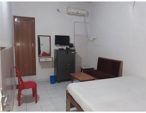 a bedroom with a bed and a chair and a mirror at Hotel Vishal, Gaya in Gaya