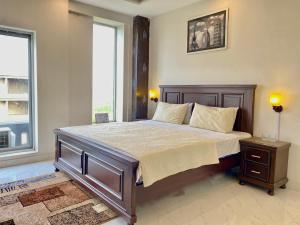 a bedroom with a large bed and two windows at 1-Bed Elegant Condo at Eiffel TW in Rāmkot