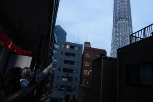 Ein Mann und eine Frau stehen auf einem Balkon in einer Stadt in der Unterkunft Geisha Expelience Stay in Tokio + 12 Fotos