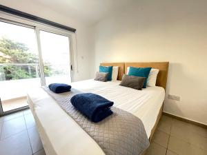 una camera con due letti con cuscini blu sopra di Aurora Holiday Apartment - Ayia Napa a Ayia Napa