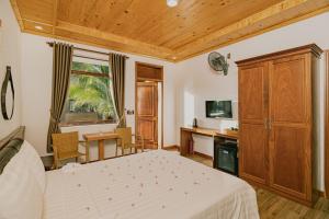a bedroom with a bed and a wooden ceiling at Valentina Resort & Spa Phu Quoc in Phú Quốc
