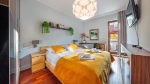 um quarto com uma cama com um cobertor amarelo em Apartamenty Sun & Snow Sopocka Rezydencja em Sopot