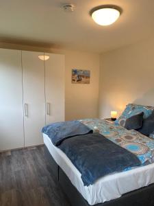 a bedroom with a large bed with a blue comforter at Dahmer Strand W 14 in Dahme