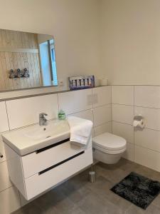 a white bathroom with a sink and a toilet at Dahmer Strand W 14 in Dahme