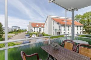 a balcony with a wooden table and chairs at Yachthafenresidenz-Wohnung-8204-852 in Kühlungsborn
