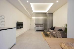 - un salon avec un canapé et une télévision dans l'établissement AT Presidente Nº3 apartamento privado completo, à Séville