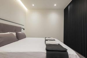 a bedroom with a large white bed with a black wall at AT Presidente Nº3 apartamento privado completo in Seville