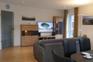 sala de estar con sofá y TV de pantalla plana en Dahmer Strand 16 Sonnenloge, en Dahme