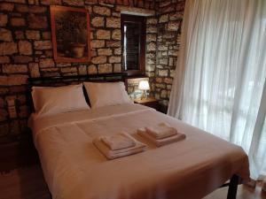 a bedroom with a bed with towels on it at Mansion Michalis in Rodavgí