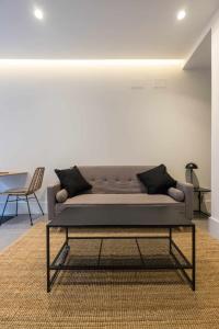 um sofá num quarto com uma mesa e cadeiras em AT Presidente Nº4 apartamento privado completo em Sevilha
