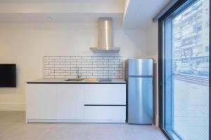 uma cozinha com um frigorífico de aço inoxidável e uma janela em AT Presidente Nº4 apartamento privado completo em Sevilha