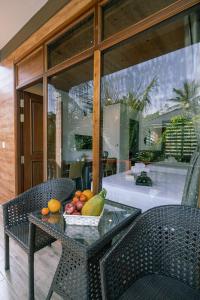 Valentina Resort & Spa Phu Quoc في فو كووك: طاولة زجاجية مع وعاء من الفواكه عليها
