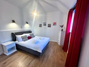 1 dormitorio pequeño con 1 cama y puerta roja en Happy Sandy Feet - Modern, Cozy & Warm Holiday Home with Lovely Sea Views in Youghal`s Heart - Top-Notch Electric Heaters - Long Term Price Cuts, en Youghal