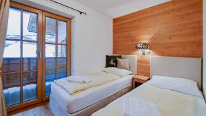 two beds in a room with a window at Chalet Wohnung Wilder Kaiser in Kitzbühel