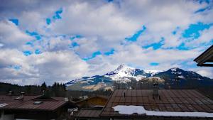 a snow covered mountain in the distance behind a roof at Chalet Wohnung Wilder Kaiser in Kitzbühel