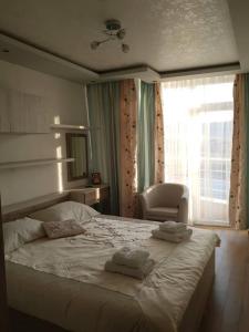 a bedroom with a large bed with towels on it at Luxury Two Bedroom Flat in Blagoevgrad