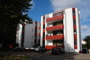 a red and white building with two cars parked in front at Lindenhof Wohnung 20 in Dahme