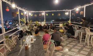 a group of people sitting on a rooftop at night at Raahi Backpacker's Hostel in Udaipur
