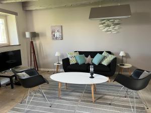 uma sala de estar com um sofá preto e uma mesa em les demeures de Kerbosser em Ploeren