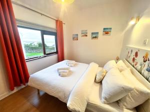 1 dormitorio con 1 cama con toallas en Happy Sandy Feet - Modern, Cozy & Warm Holiday Home with Lovely Sea Views in Youghal`s Heart - Top-Notch Electric Heaters - Long Term Price Cuts, en Youghal