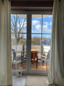 een glazen schuifdeur met een tafel en stoelen op een balkon bij Seeschloss Wohnung 22 in Dahme