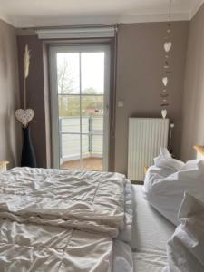 een slaapkamer met een wit bed en een groot raam bij Seeschloss Wohnung 22 in Dahme