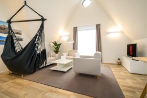 una sala de estar con una hamaca en una habitación en Zolima - Apartment - Familie - Paare - E-Bike Ladestation, en Stolpe auf Usedom