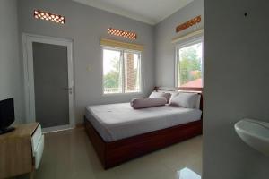 A bed or beds in a room at Hotel Sakura Puncak