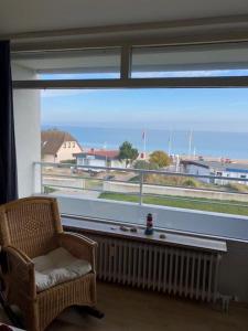 a room with a large window with a chair and a radiator at Strandhotel Wohnung 33 in Dahme