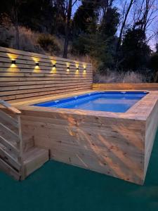 a swimming pool with a wooden deck and a swimming poolvisor at Cabañas del Maipo in San José de Maipo