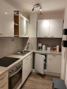 a kitchen with white cabinets and a sink at Strandhotel Wohnung 24 in Dahme