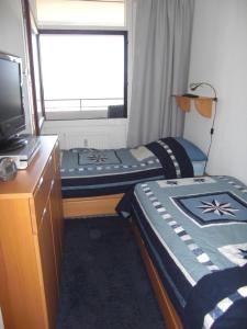 a room with two twin beds and a television at Strandhotel Wohnung 28 in Dahme