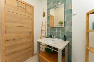 a bathroom with a sink and a wooden door at Abrigo do Castelo - Pica-Pau in Ourém +14 photos